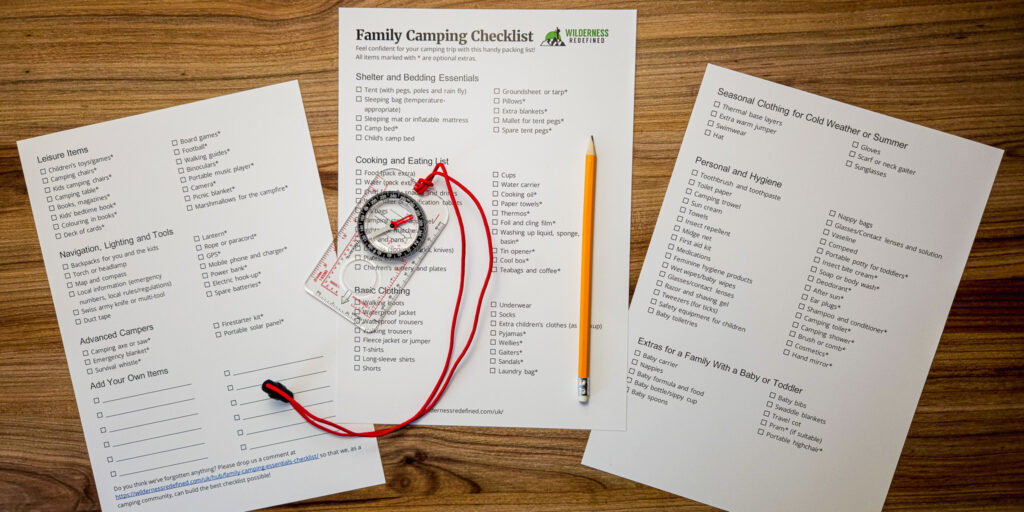 Photo of a printed family camping essentials checklist with compass and pencil lying on a wooden table