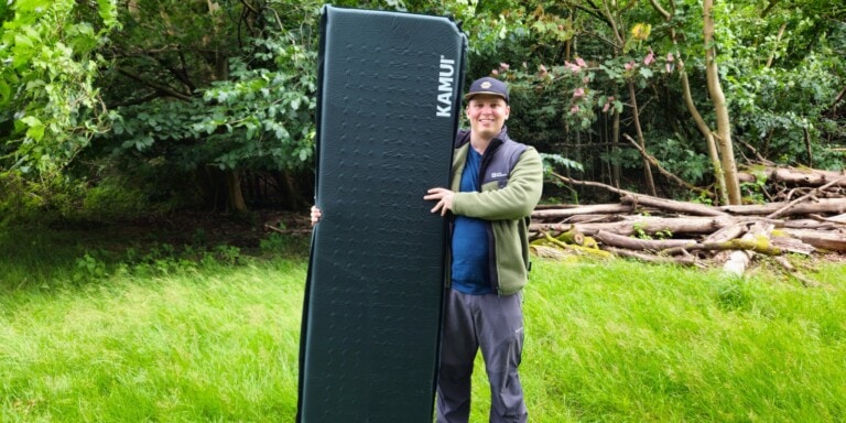 Camper holding a camping mattress in our Kamui sleeping mat review