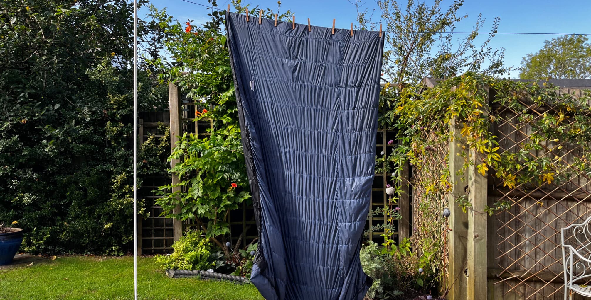 a down sleeping bag hanging up on a washing line