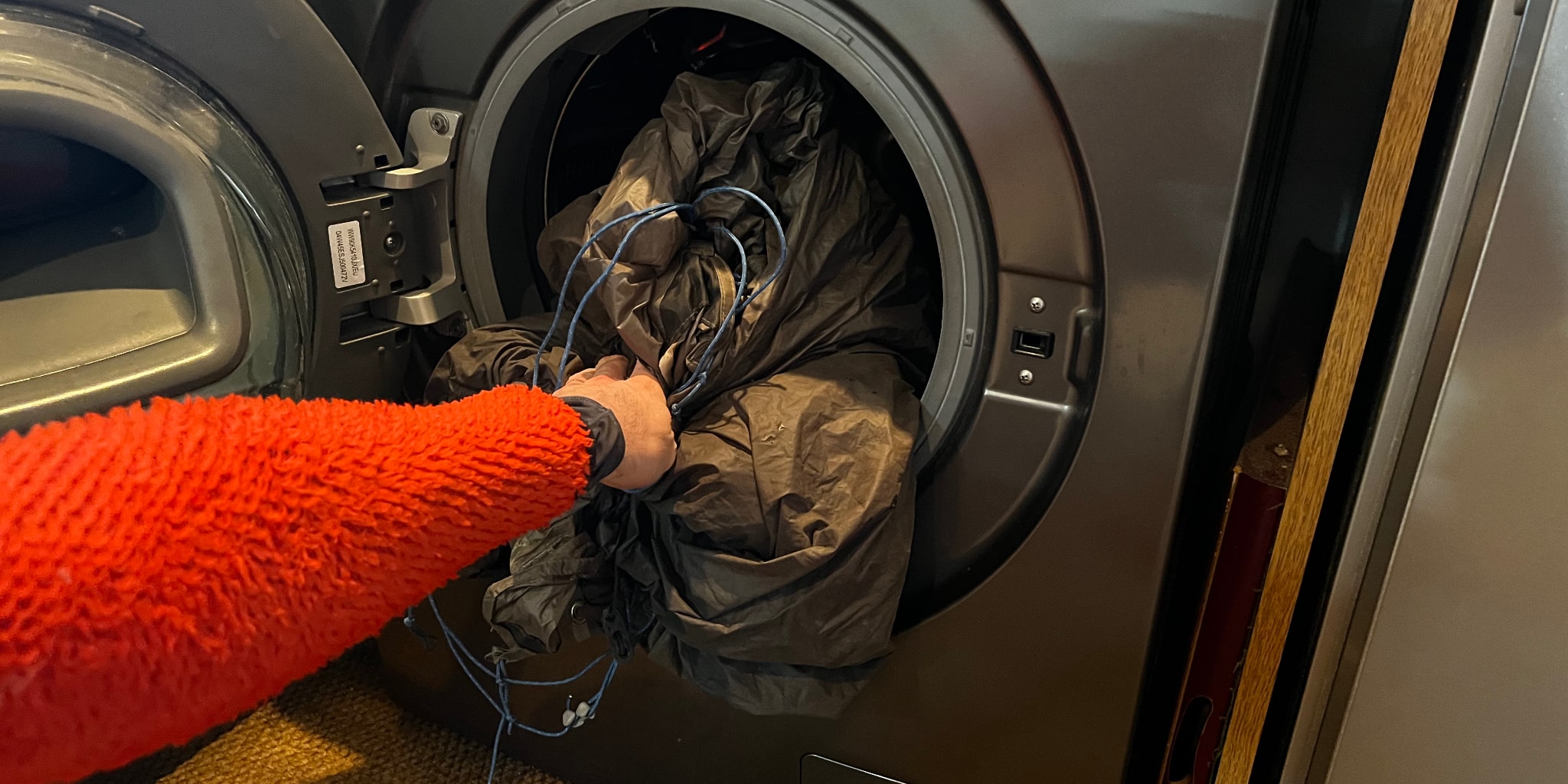 Someone holds a tent inside a washing machine