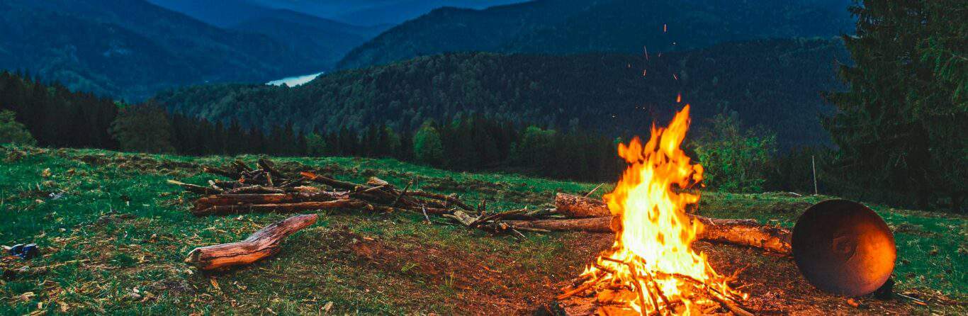 Campfire Burning In Front Of Mountains