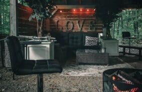 A glamping living space with comfortable furniture and a fire pit