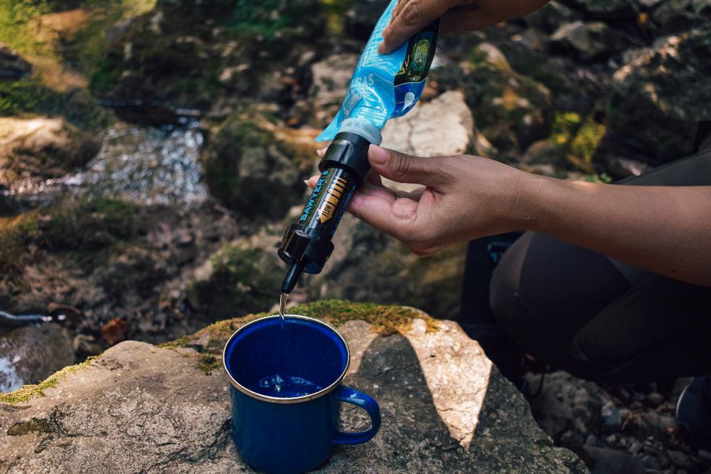 A Sawyer water filter dispensing into a mug