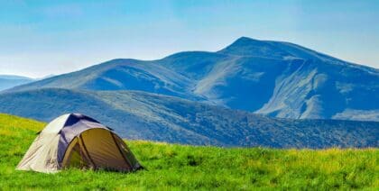 A tent pitched in front of rolling hills