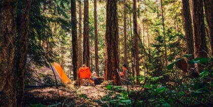 A family sat around their forest campsite