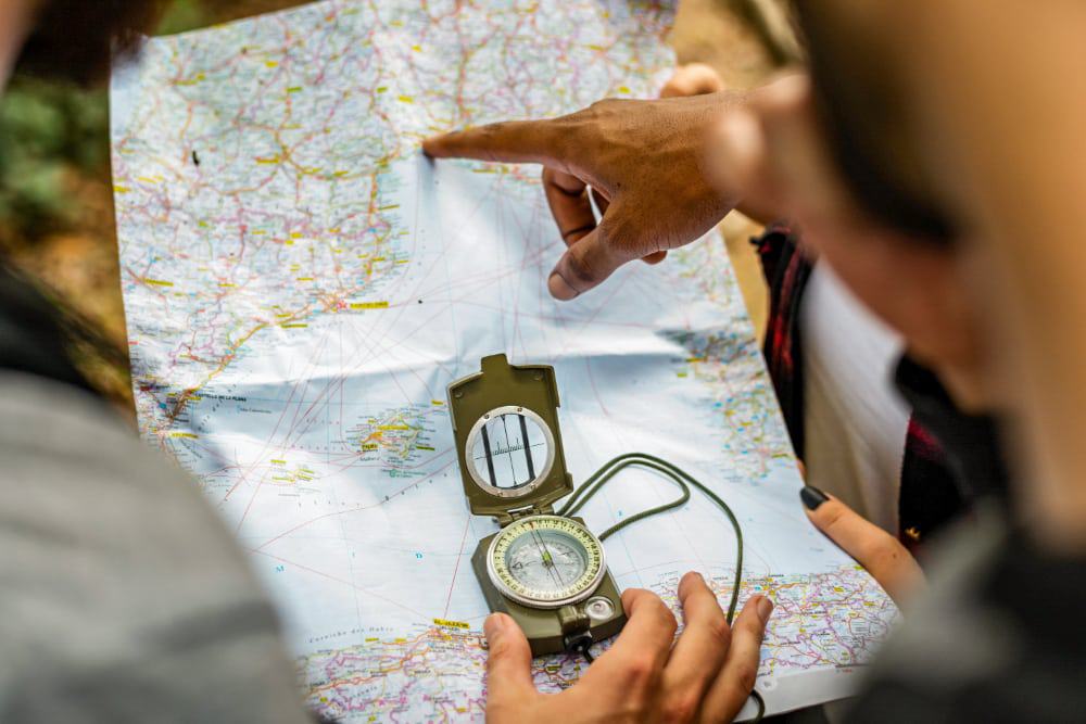 Hikers using a map and compass to find their trail 