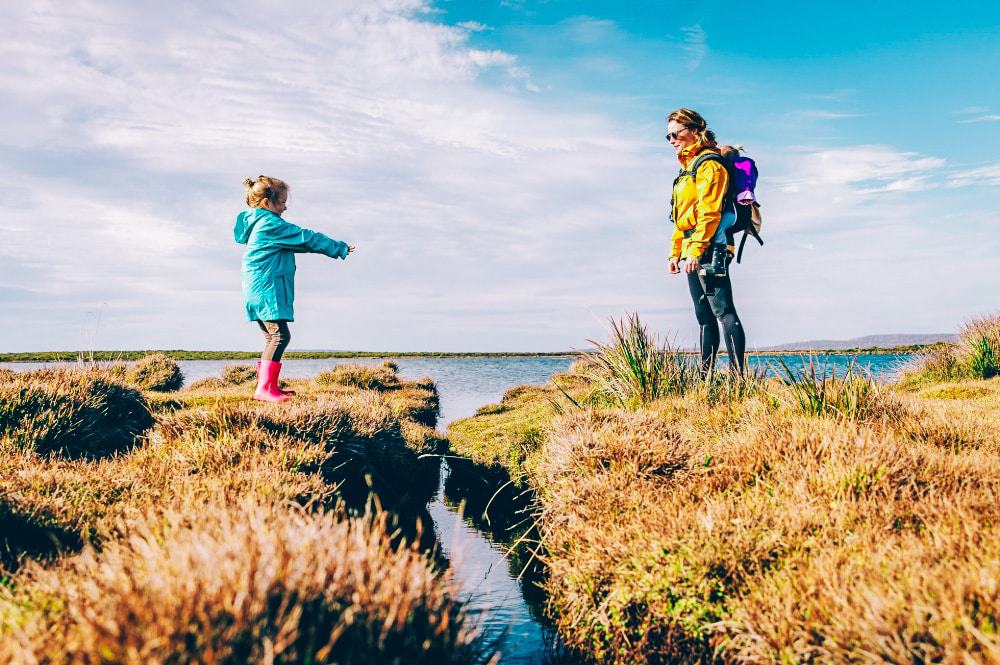 A mother and daughter crossing a stream