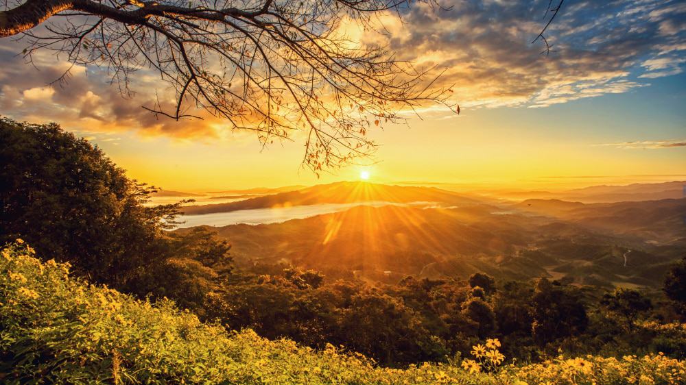 A sunrise over a hill in the distance