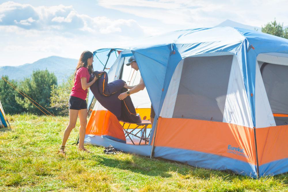 Two campers setting up the Eureka Copper Canyon, a great alternative we've included in our Coleman 10 Person Instant Cabin Tent review