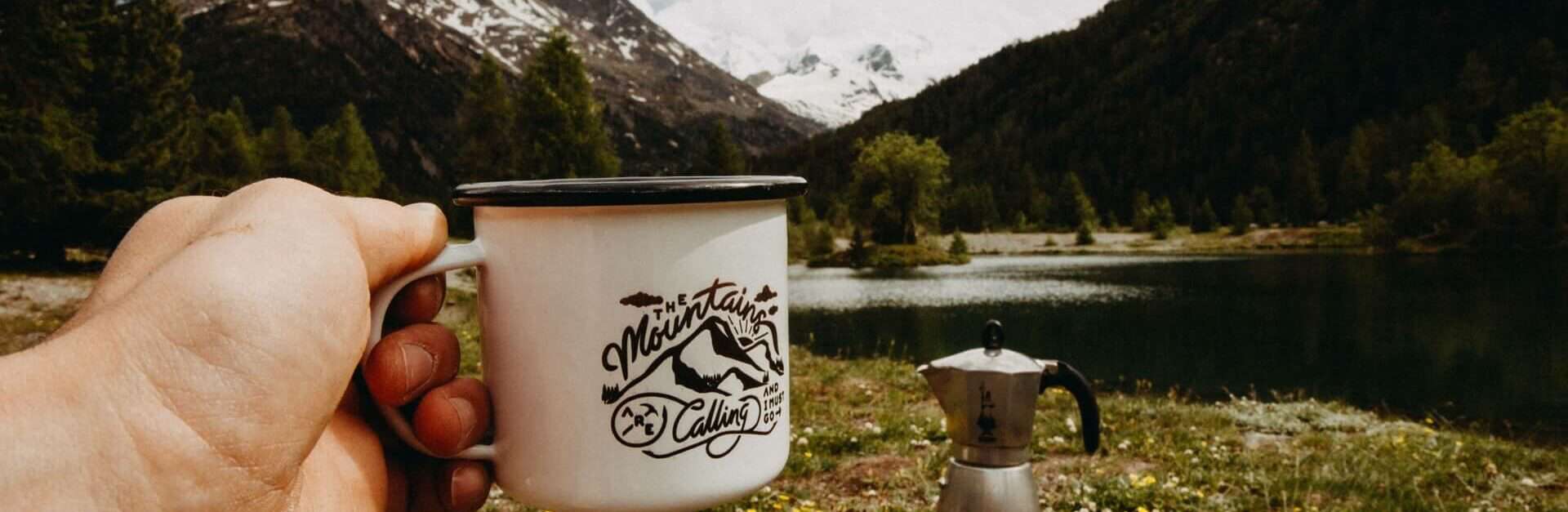 A mug and coffee pot in the wilderness
