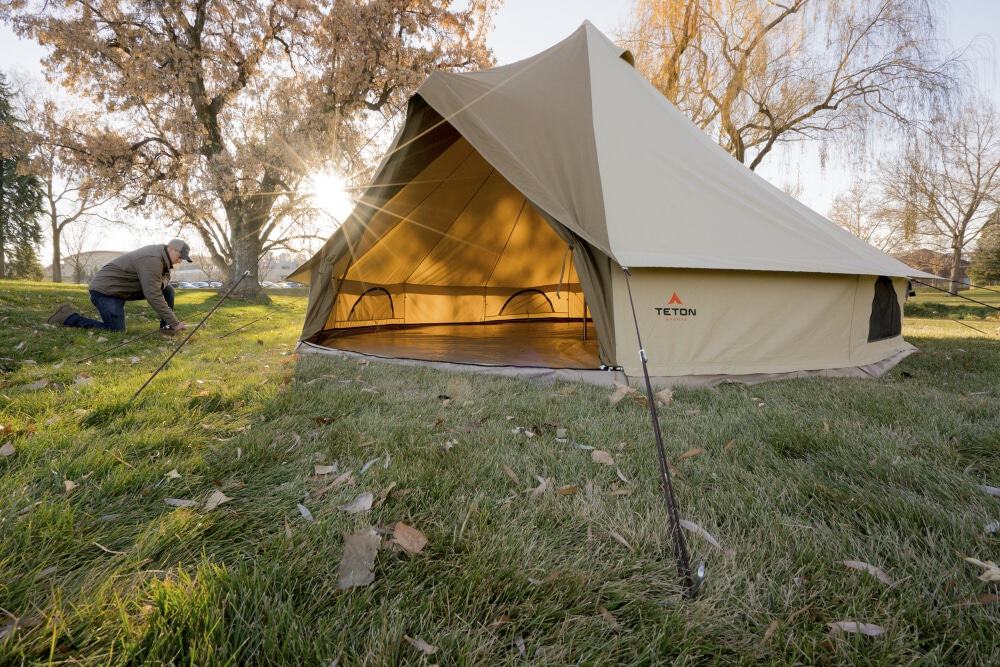 A man pegging down the guylines of the 10 person TETON Sports Sierra tent - one the most durable of the tents on this review you can buy from Amazon