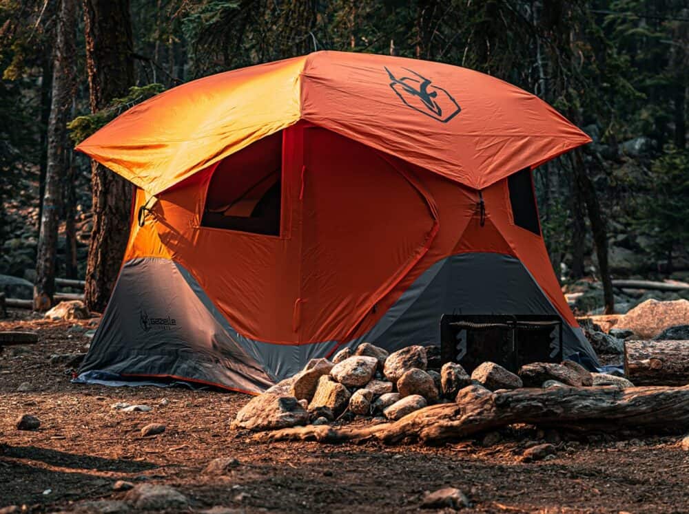 The Gazelle T4 Tent set up beside a campfire in the great outdoors.