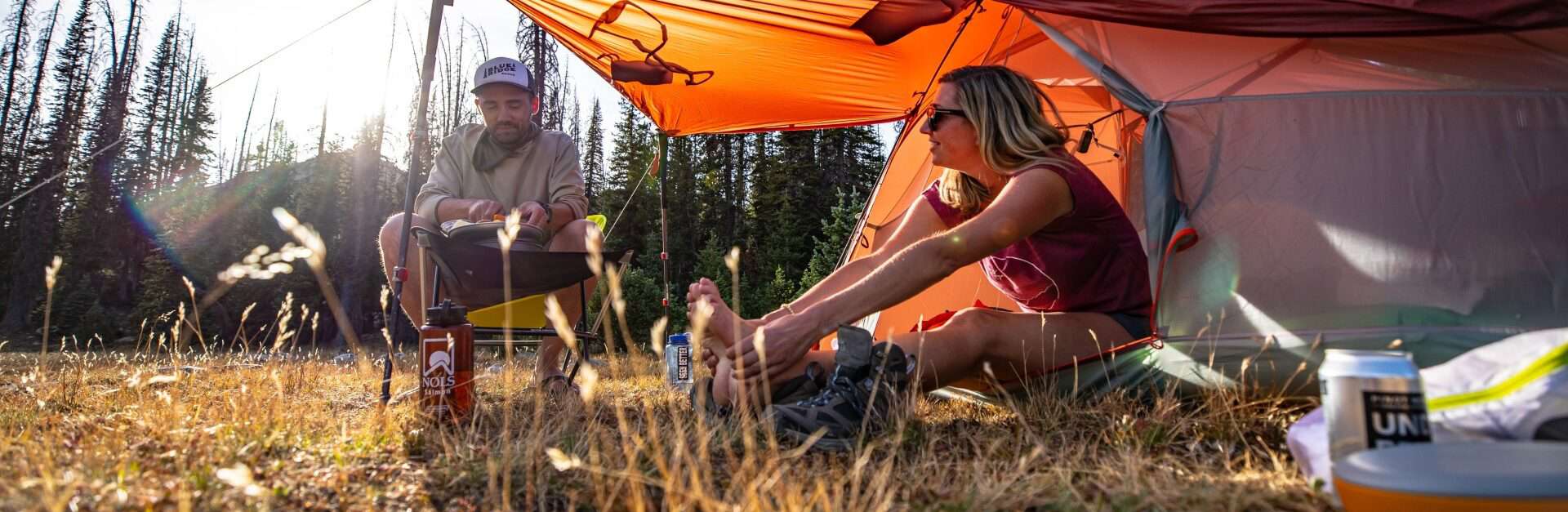 Two campers sat by their Big Agnes Copper Spur backpacking tent
