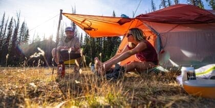 Two campers sat by their Big Agnes Copper Spur backpacking tent with the vestibule open