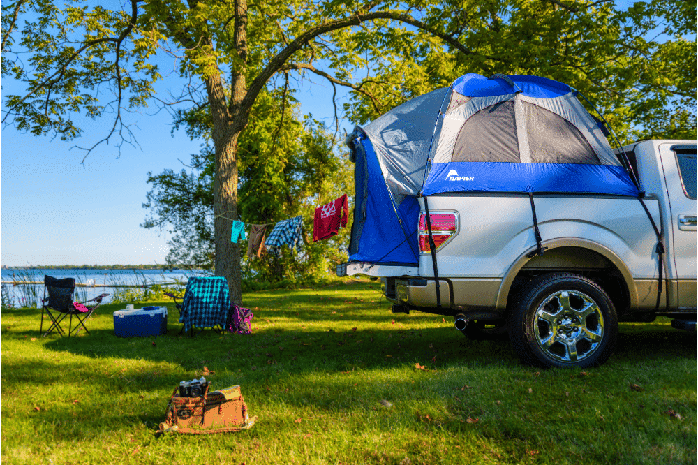 Campers making the most of their Napier Sportz Truck Tent with a washing line hooked up to the truck and camping chairs behind the tent