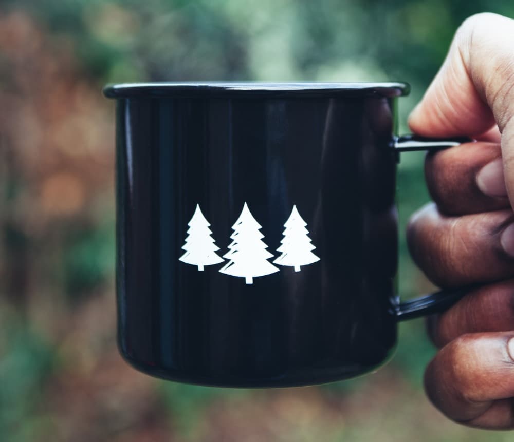 A man out hiking holding a warm cup of tea