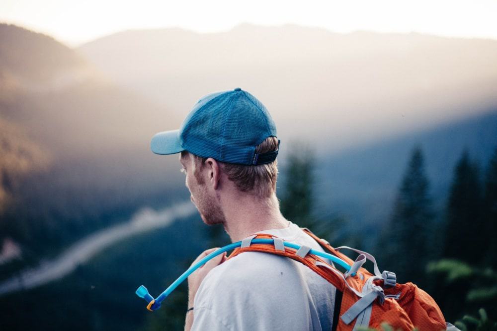 Man walking in the mountains with a rehydration backpack