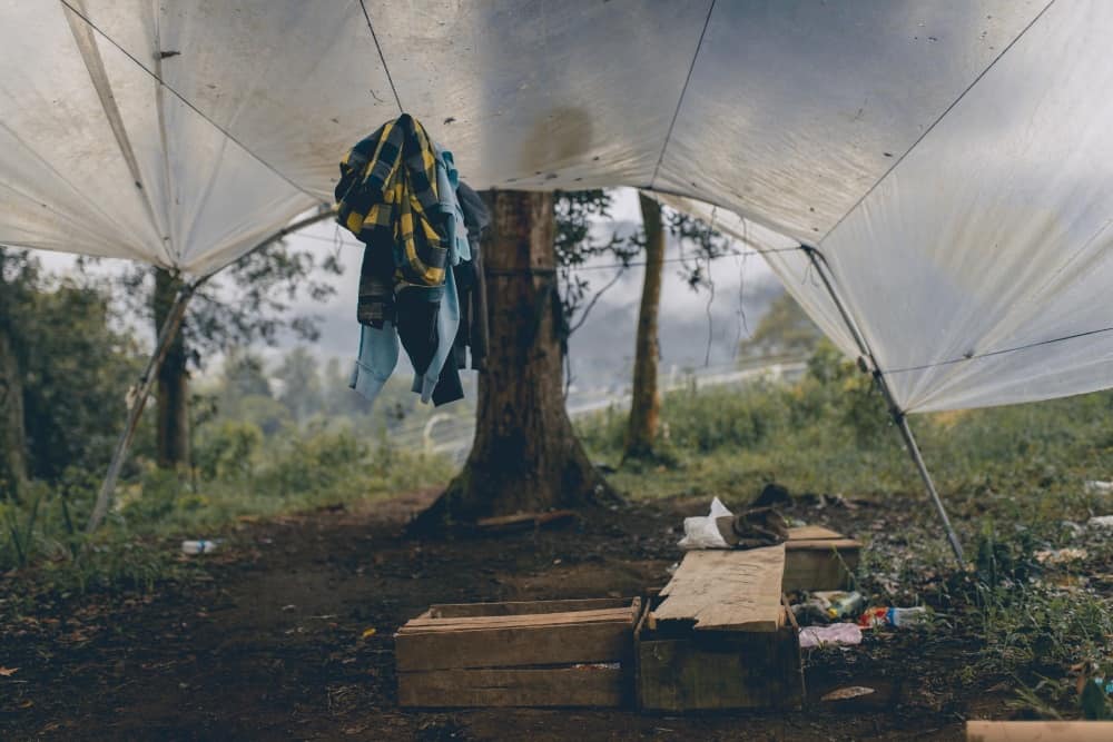 Clothes hanging under a makeshift tarp tent in a campsite