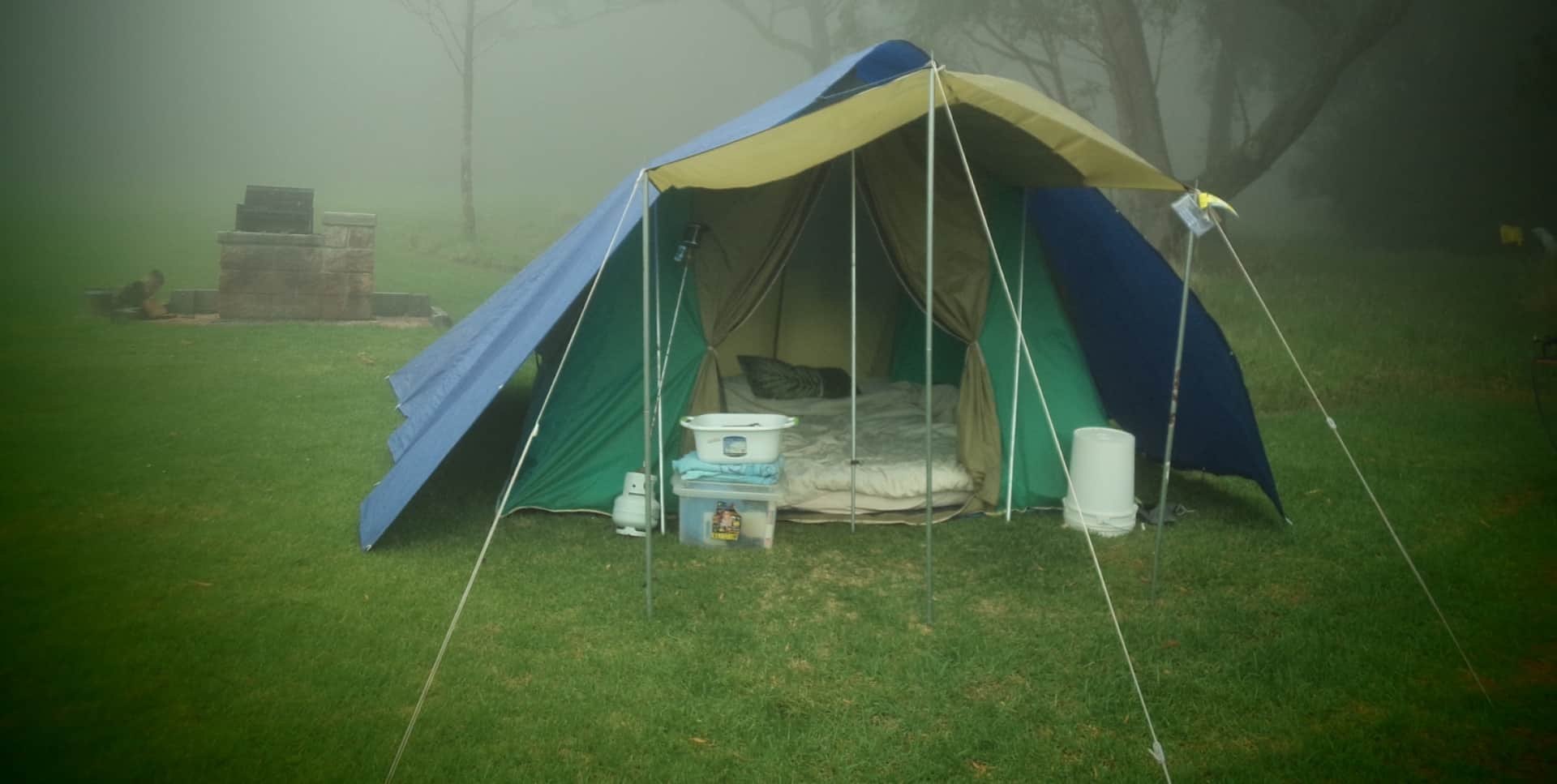 Canvas tent set up in misty weather at a campsite