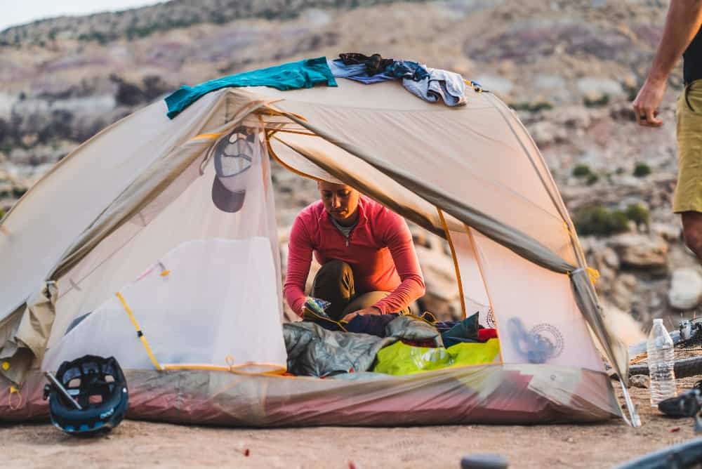 Bike riders setting up a double-wall tent for the night with a lot of gear to sort out