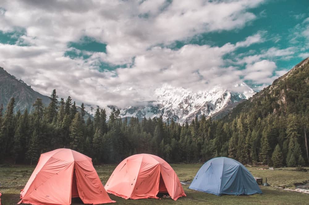 A single grey double wall tent with its tent fly wall set up in the forest