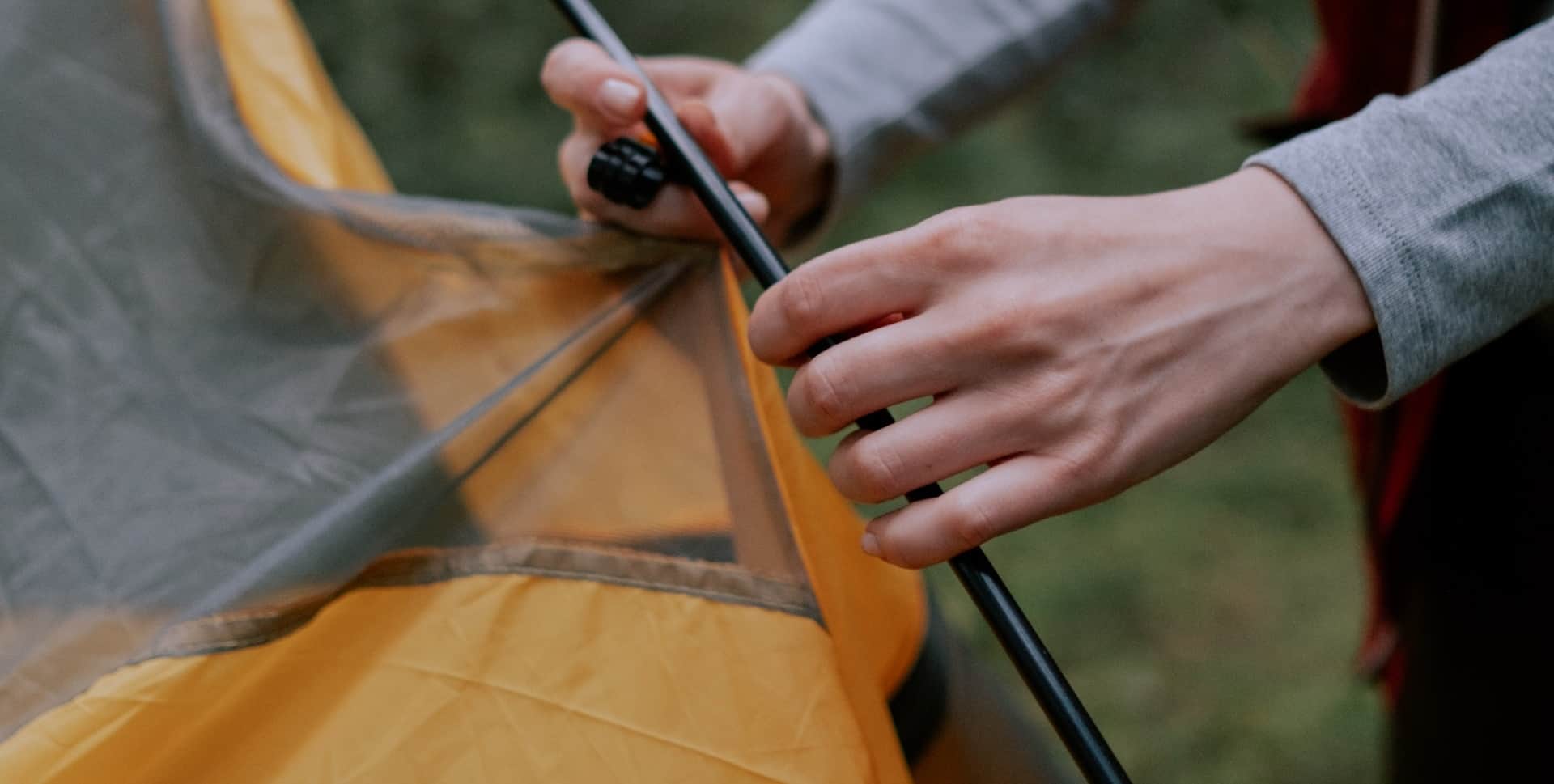 Person’s hands clipping a tent inner to a pole