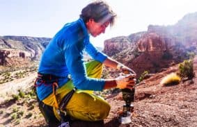 Backpacker Setting Up Jetboil Stove With Jetpower Fuel Canister
