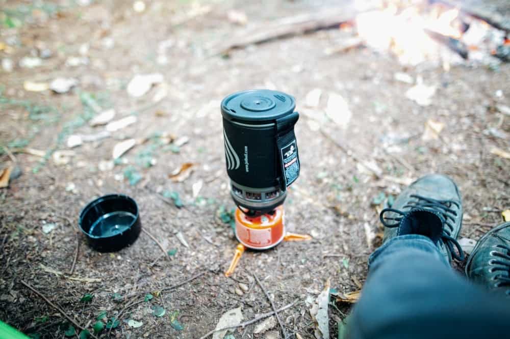 A backpacker sitting beside a jetboil stove with jetpower fuel
