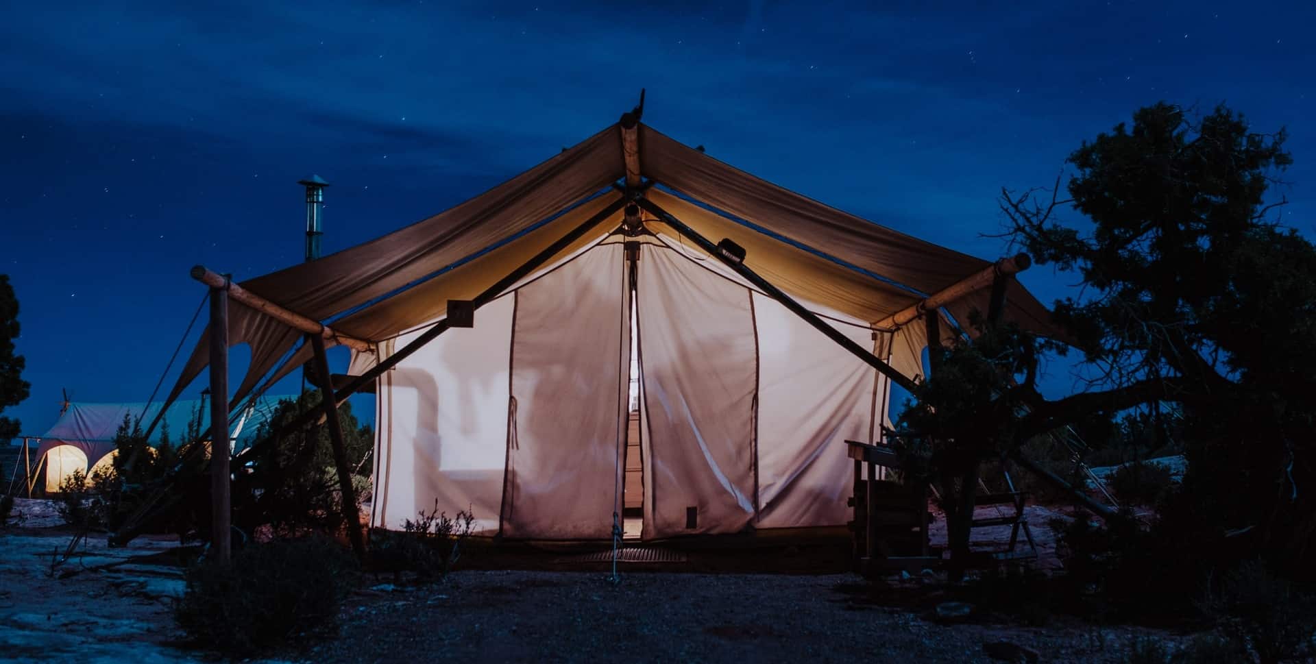 Large Tent with a large size tarp set up on a beach.