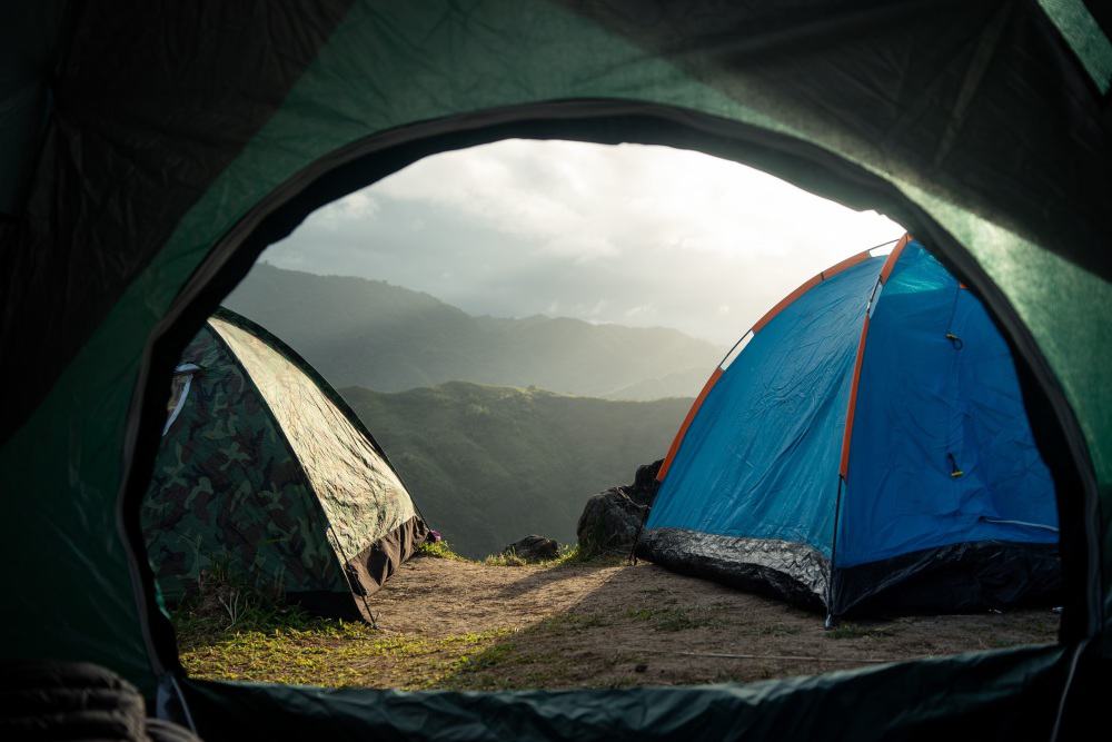 Looking out of tent at two other tents across a mountain valley