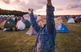 Woman Dancing In Front Of Instant Tent At Festival