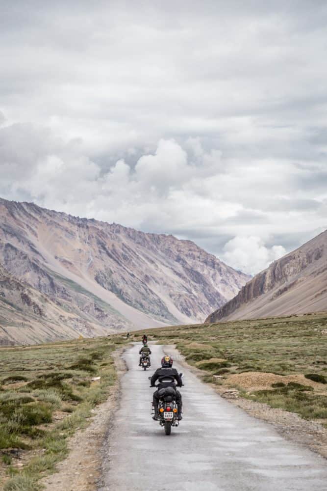 Three bikers traveling a mountain road with packed panniers.