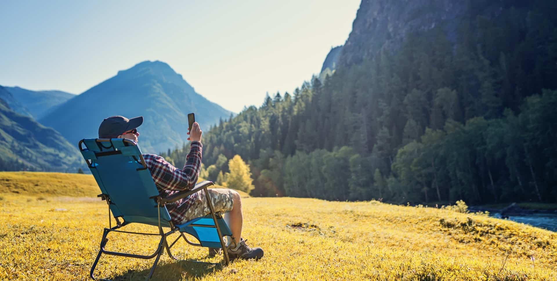 A camper sitting in a reclining camp chair outdoors