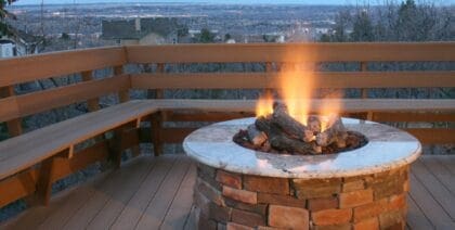 A fire pit sitting on a wood deck keeping the area warm