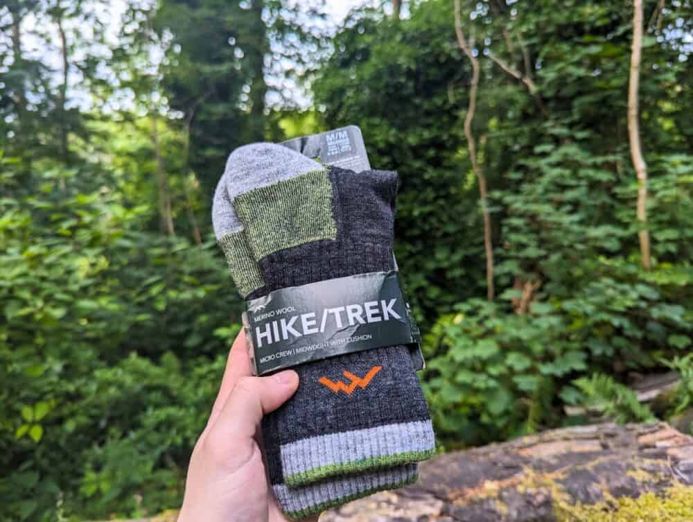 Darn Tough hiking socks being held in forest