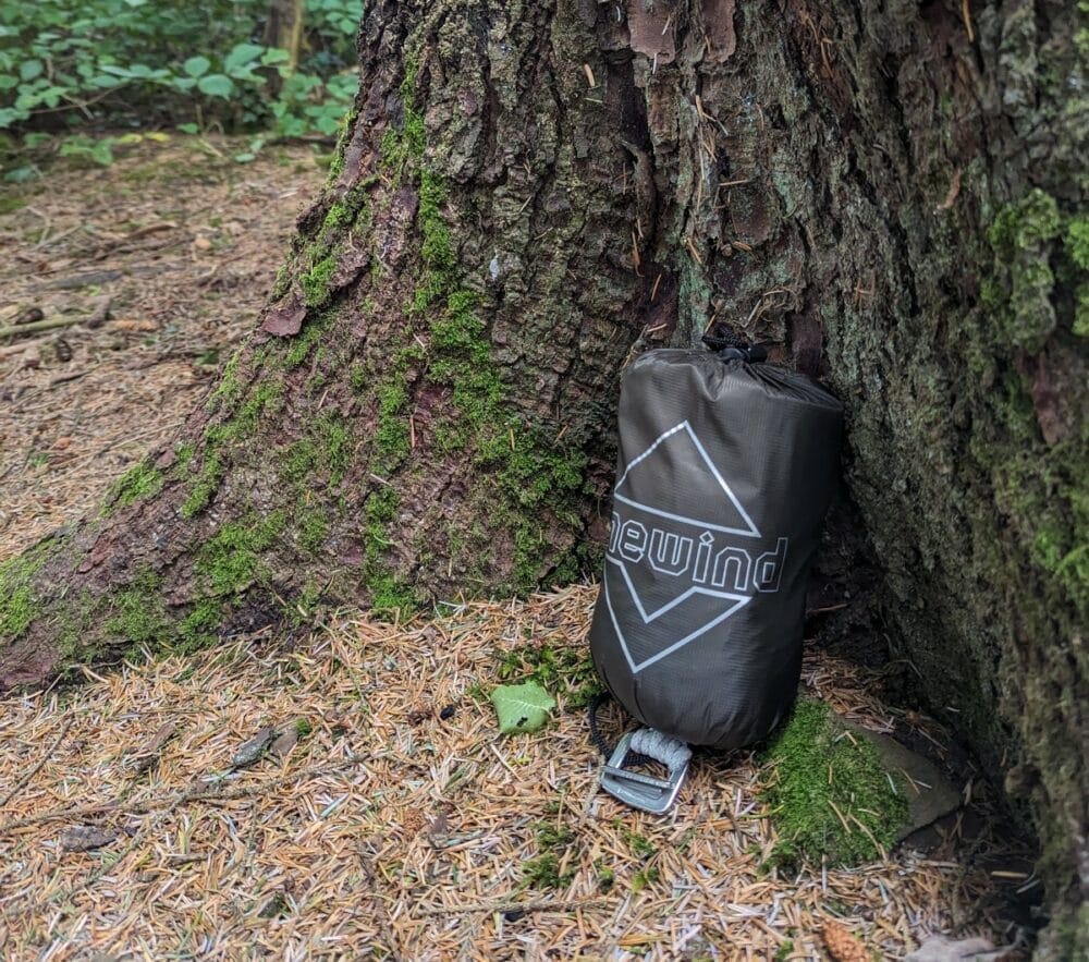 Onewind Whirlwind carry bag sitting against a tree outdoors